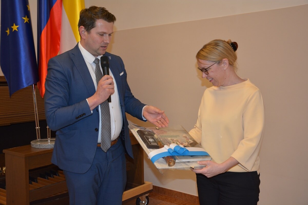 Župan Matej Slapar gostji dr. Heleni Jaklitssch predaja spominsko darilo Občine Kamnik.